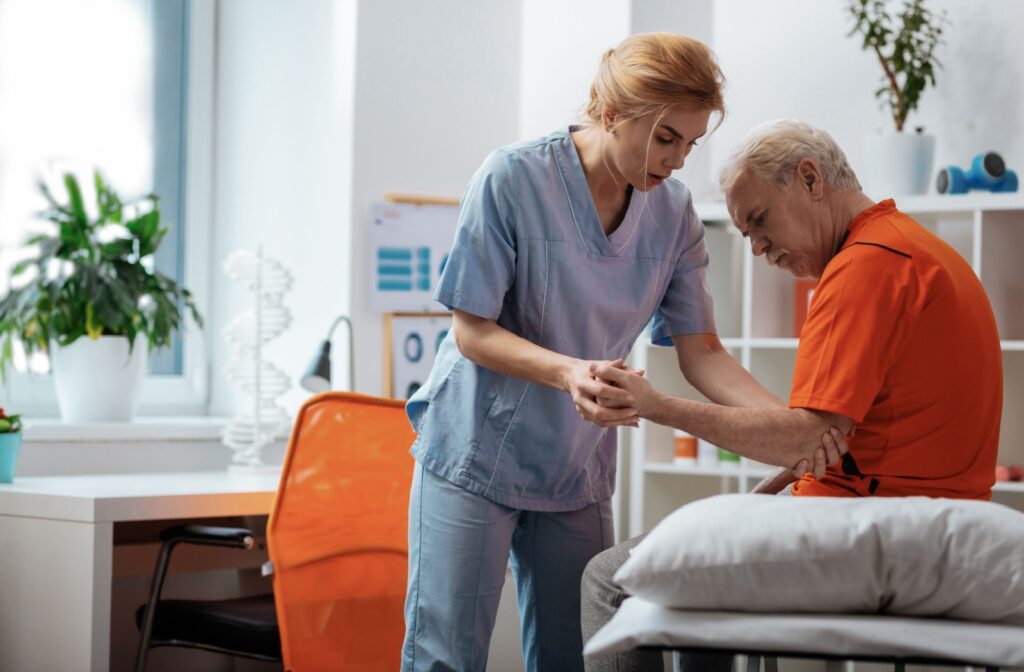 A skilled care nurse examines a senior resident's arm gently.